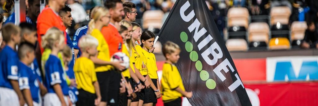 Foto van voetbalwedstrijd met Unibet vlaggen